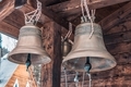 Bronze bells of an old wooden chapel. Old bronze bells in a village church - PhotoDune Item for Sale
