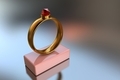 3D illustration of a gold ring with a big red diamond on a pink stand - PhotoDune Item for Sale