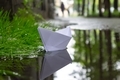 The paper boat floats on the stream after a heavy rain between the streets of the city - PhotoDune Item for Sale