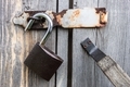 Steel and reliable padlock hanging on the wooden doors of the old barn in the open position - PhotoDune Item for Sale
