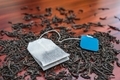 Delicious black loose tea and tea bags lie on a wooden table - PhotoDune Item for Sale