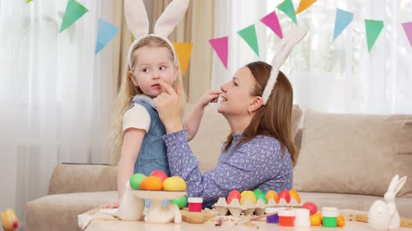 Mom and Little Daughter with Rabbit Ears Celebrate Easter and and Have Fun