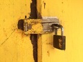 An old rusted lock on a bright yellow door  - PhotoDune Item for Sale