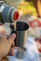 close up pfoto of pouring tea in the mug at the daytime on the picnic - PhotoDune Item for Sale