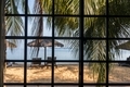View on the tropical beach through the window and palm branches  - PhotoDune Item for Sale