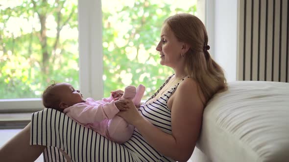 Happy Baby Lying on Mother Knees Mom Playing with Infant Daughter Spbd