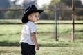Little caucasian boy standing in a pasture wearing his cowboy hat and Hensley.  Concentration. - PhotoDune Item for Sale