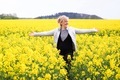 Happy smiling woman in the field of yellow blooming flowers  - PhotoDune Item for Sale