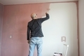 Full length of a man painting the pink wall.  - PhotoDune Item for Sale