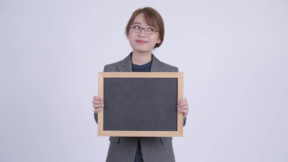 Young Happy Asian Businesswoman Thinking While Holding Blackboard