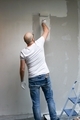 Full length of a man painting the wall in white. New home. Home renovation. - PhotoDune Item for Sale