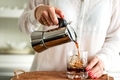 Iced coffee in the summer. Woman pouring black coffee in to the glass with the ice cubes. - PhotoDune Item for Sale