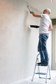 Man with the white t-shirt painting wall in the white color. Renovation. - PhotoDune Item for Sale