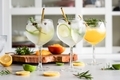 Gin and tonic with green lime and rosemary in the cocktail glass with ice cubes - PhotoDune Item for Sale