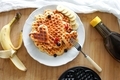 Stacked waffles in a white plate with sugar syrup, berries and banana slices ready to eat. - PhotoDune Item for Sale