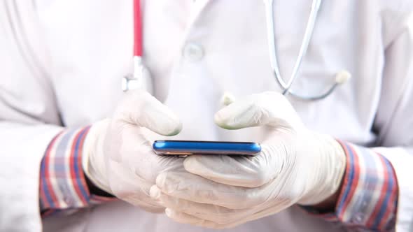 Doctor Hand in Medical Gloves Using Smart Phone Texting