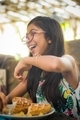 Candid pic of a happy young girl enjoying her breakfast at a restaurant - PhotoDune Item for Sale