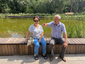 Seniors are sitting on the bench at the botanical garden in the bright sunny day - PhotoDune Item for Sale