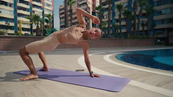 Sporty Woman Doing Workout with an Animal Flow Move Outdoor Near the Pool