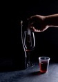 A man prepares wine in a glass for shooting by pouring wine through a syringe without splashing - PhotoDune Item for Sale