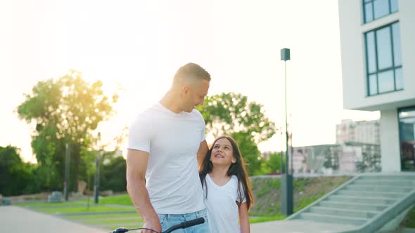 Dad and Daughter Walk Around Their Area After Cycling at Sunset