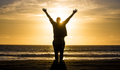 Silhouetted man with his arms out enjoying his vacation overlooking a golden sunset. - PhotoDune Item for Sale