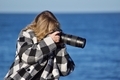 A professional photographer at sunrise taking photos with her zoom lens on the cliffs in La Jolla
 - PhotoDune Item for Sale