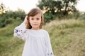 Portrait of beautiful six year old girl standing in field sunset in nature - PhotoDune Item for Sale