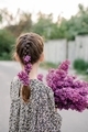 Cute little girl wearing dress holds a large bouquet of lilacs flowers. Spring concept - PhotoDune Item for Sale
