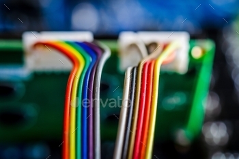 Visualizing data, color coded electrical wires are plugged into a computer printed circuit board