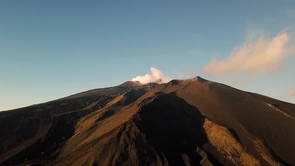 Drone view of Etna volcano on Sicily, Italy with smoke on a sunny day with a blue sky