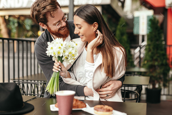 iful lady after giving flowers during first date in street cafe