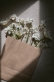 Paper bag mock up. Fresh flowers in blank paper bag in sunlight.  - PhotoDune Item for Sale