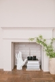 Stylish home decoration. Candles on stack of books, plaster sculpture, blooming branches, fireplace. - PhotoDune Item for Sale