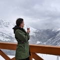 a young woman stands on the terrace of a cafe in a ski resort with a glass of mulled wine and looks  - PhotoDune Item for Sale