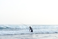 a fisherman picking something from the beach - PhotoDune Item for Sale