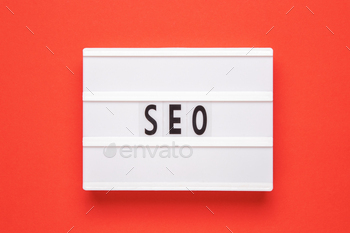 Lightbox with word SEO on red background. Search Engine Optimization ranking concept.