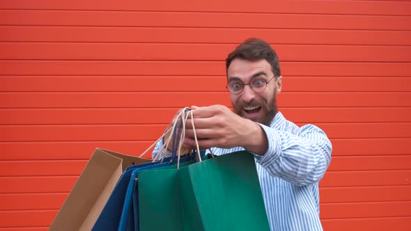 Portrait Happy Bearded Guy with Glasses Takes the Bags in His Hands. Shopping in the Store