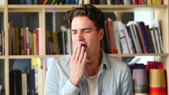 Yawning Tired Young Man in Office