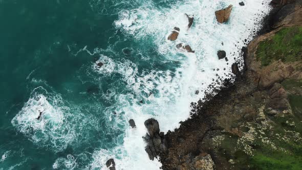 Aerial Top View Camera Lifts Up the Rocky Coast of the Cote d'Azur of the Atlantic Ocean in Cabo Da