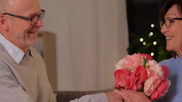 Happy Senior Couple with Bunch of Flowers at Home