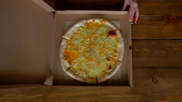 Top View - Woman Opening Box with of 4 Cheese Pizza