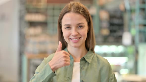 Portrait of Positive Young Woman Doing Thumbs Up 