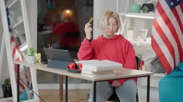 Portrait of Teen Asian Girl Sitting at Desk at Home Thinking