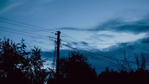 Clouds Move Across the Evening Sky, Against the Background of the Silhouette Wooden Electricity