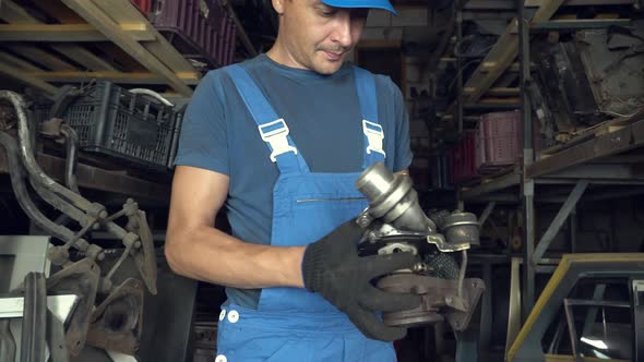 employee of auto disassembly, completes or checks car parts from tablet computer