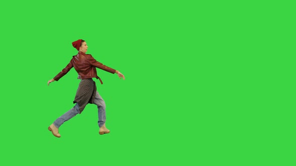 Young Girl in Urban Dance Clothes Makes a Turn and Runs Away on a Green Screen Chroma Key