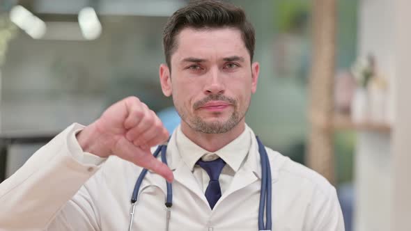 Disappointed Young Male Doctor Showing Thumbs Down 