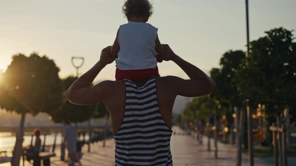 Father and Son Walking in City at Sunset