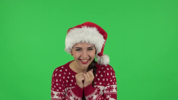 Portrait of Sweety Girl in Santa Claus Hat Is Laughing While Looking at Camera. Green Screen